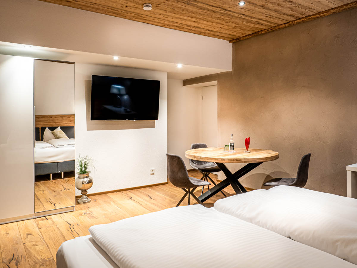 Hotel Allgäuherz Suite "Allgäu" - Schlafzimmer mit Doppelbett und Wohnbereich